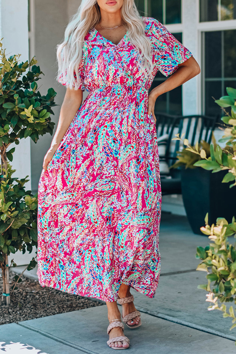 A beautiful woman wearing a Wrap V Neck Floral Maxi Dress with a vibrant floral print, flutter sleeves, and a flattering silhouette, perfect for summer occasions.