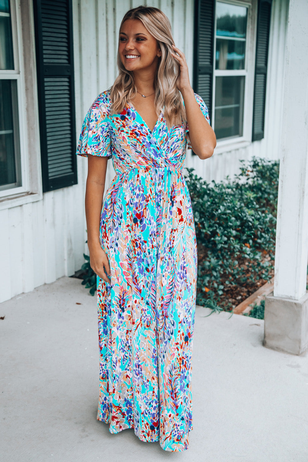 A stylish Wrap V Neck Floral Maxi Dress featuring a vibrant floral print, flutter sleeves, and a flattering wrap design, perfect for summer occasions.