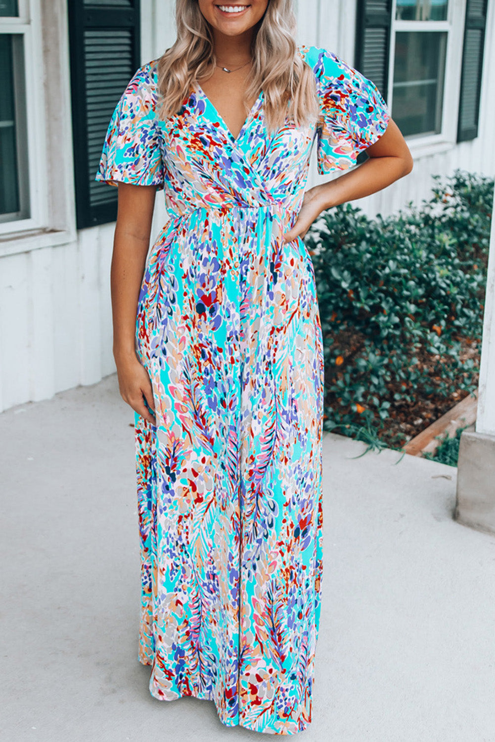 A stylish Wrap V Neck Floral Maxi Dress featuring a vibrant floral print, flutter sleeves, and a flattering wrap design, perfect for summer occasions.