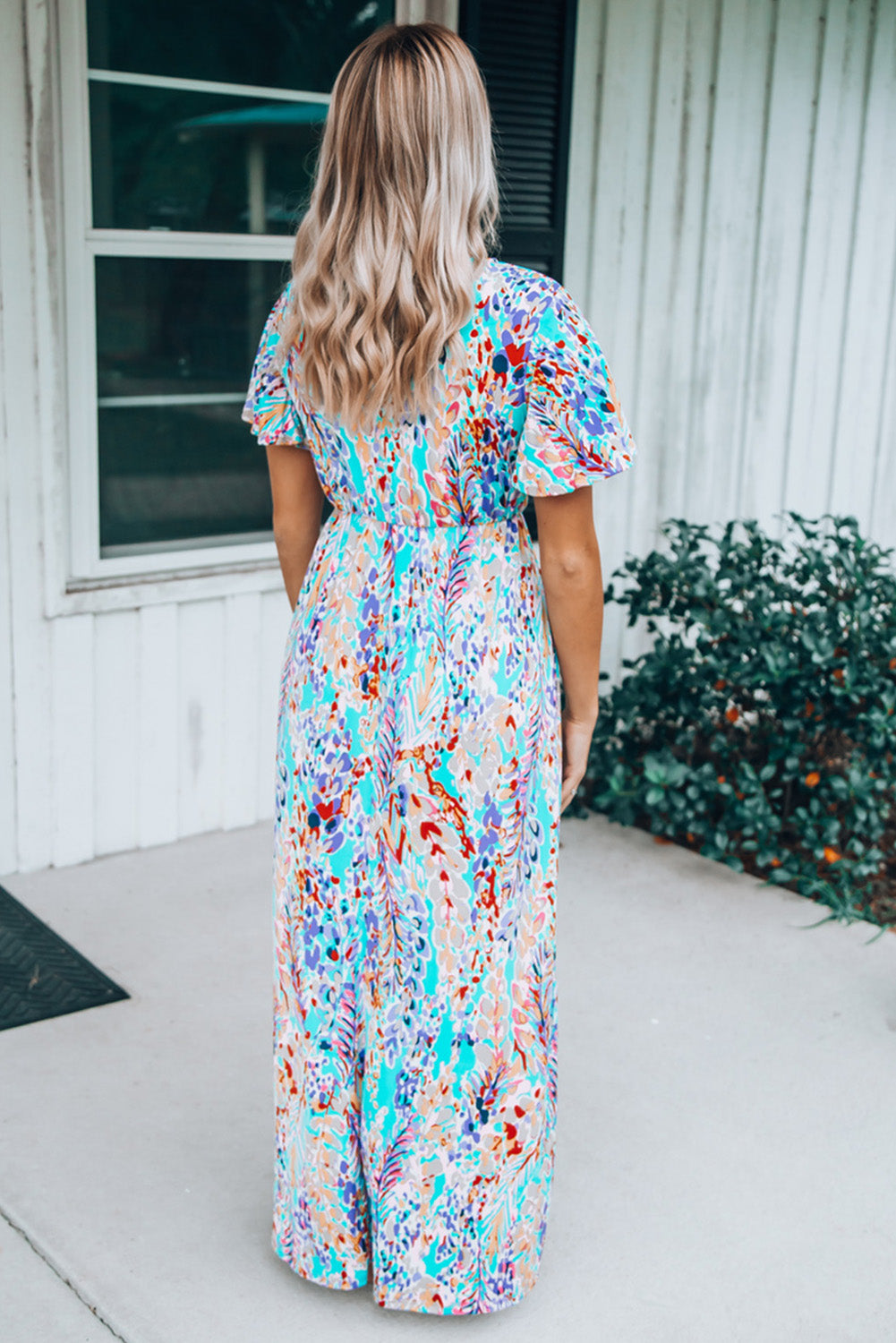 A stylish Wrap V Neck Floral Maxi Dress featuring a vibrant floral print, flutter sleeves, and a flattering wrap design, perfect for summer occasions.