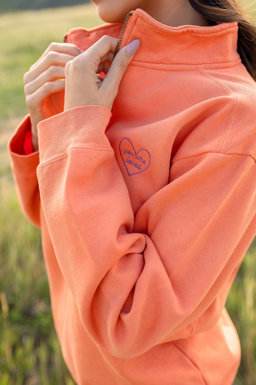 You Are Loved Half Zip Sweatshirt in coral color with heart embroidery on the left chest, showcasing a stylish half zip design.