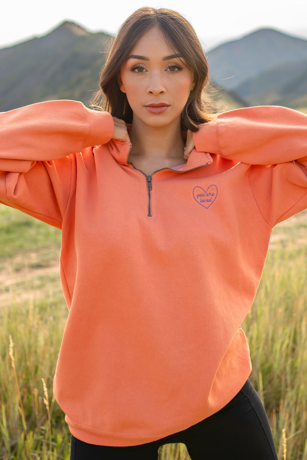 You Are Loved Half Zip Sweatshirt in coral color with heart embroidery on the left chest, showcasing a stylish half zip design.