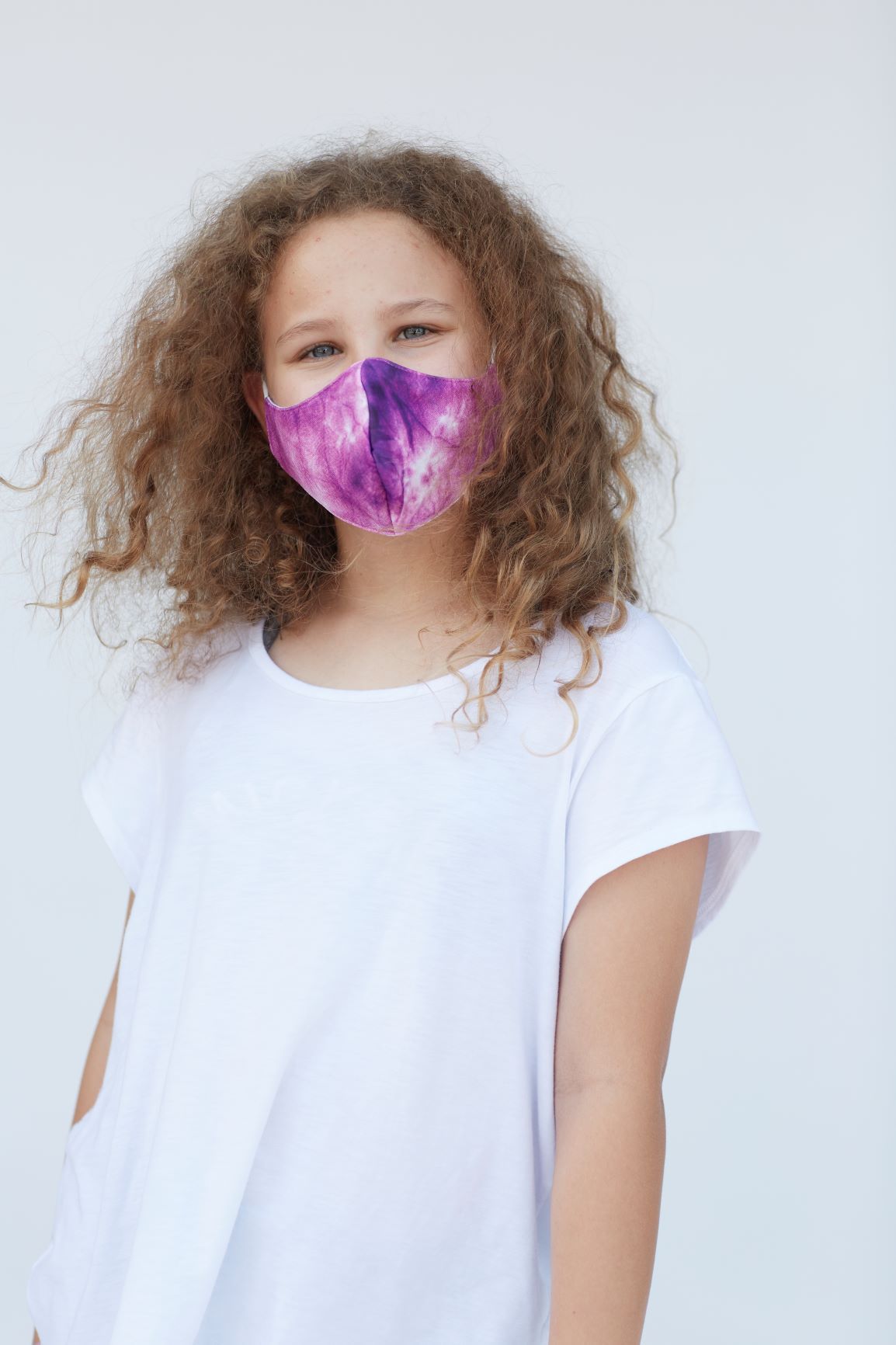 Youth Purple Tie Dye Face Mask showcasing vibrant colors and unique design, made of breathable fabric with a filter pocket.