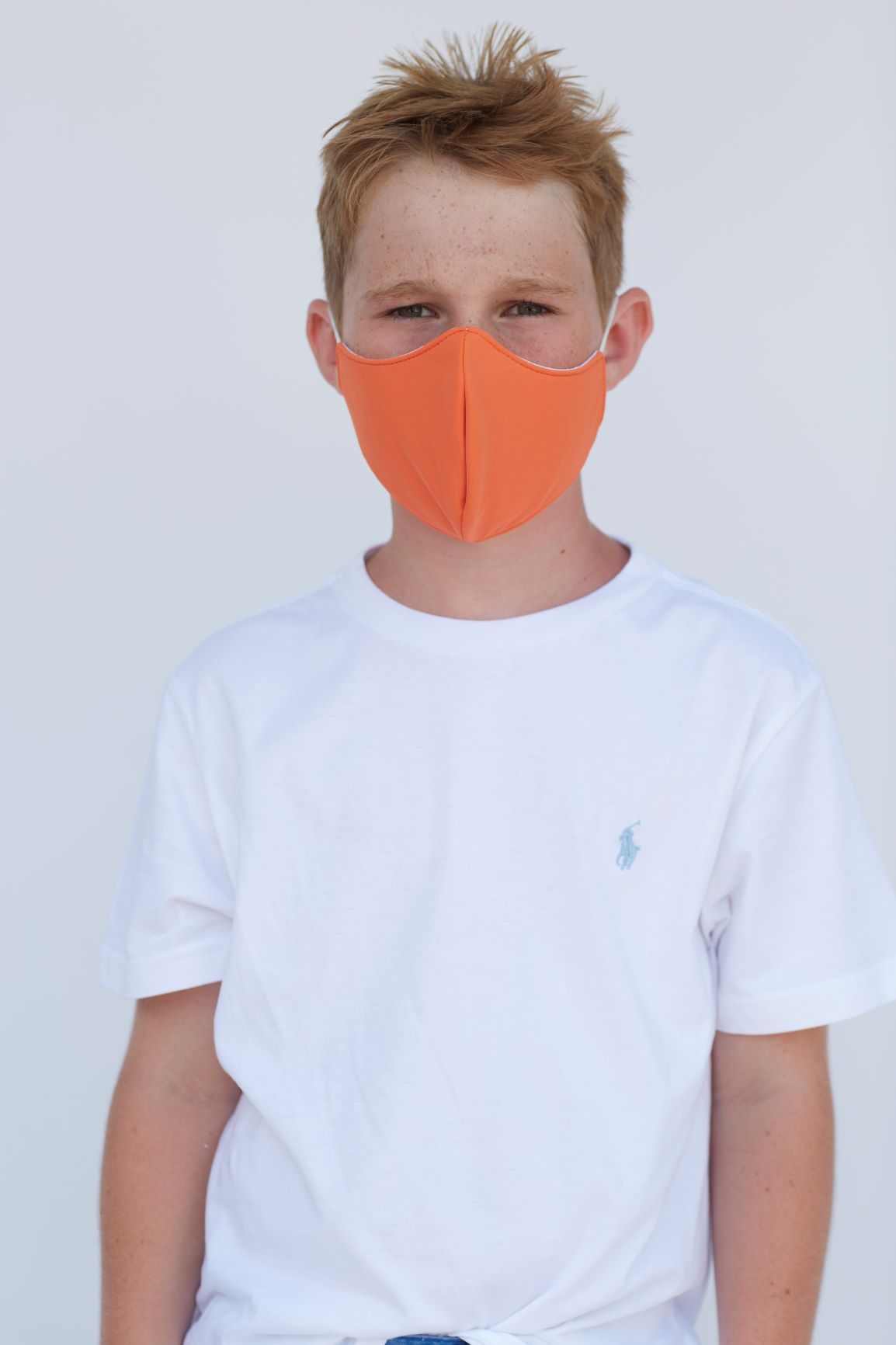 Youth Solid Orange Face Mask showcasing a vibrant orange color with a comfortable fit and filter pocket.