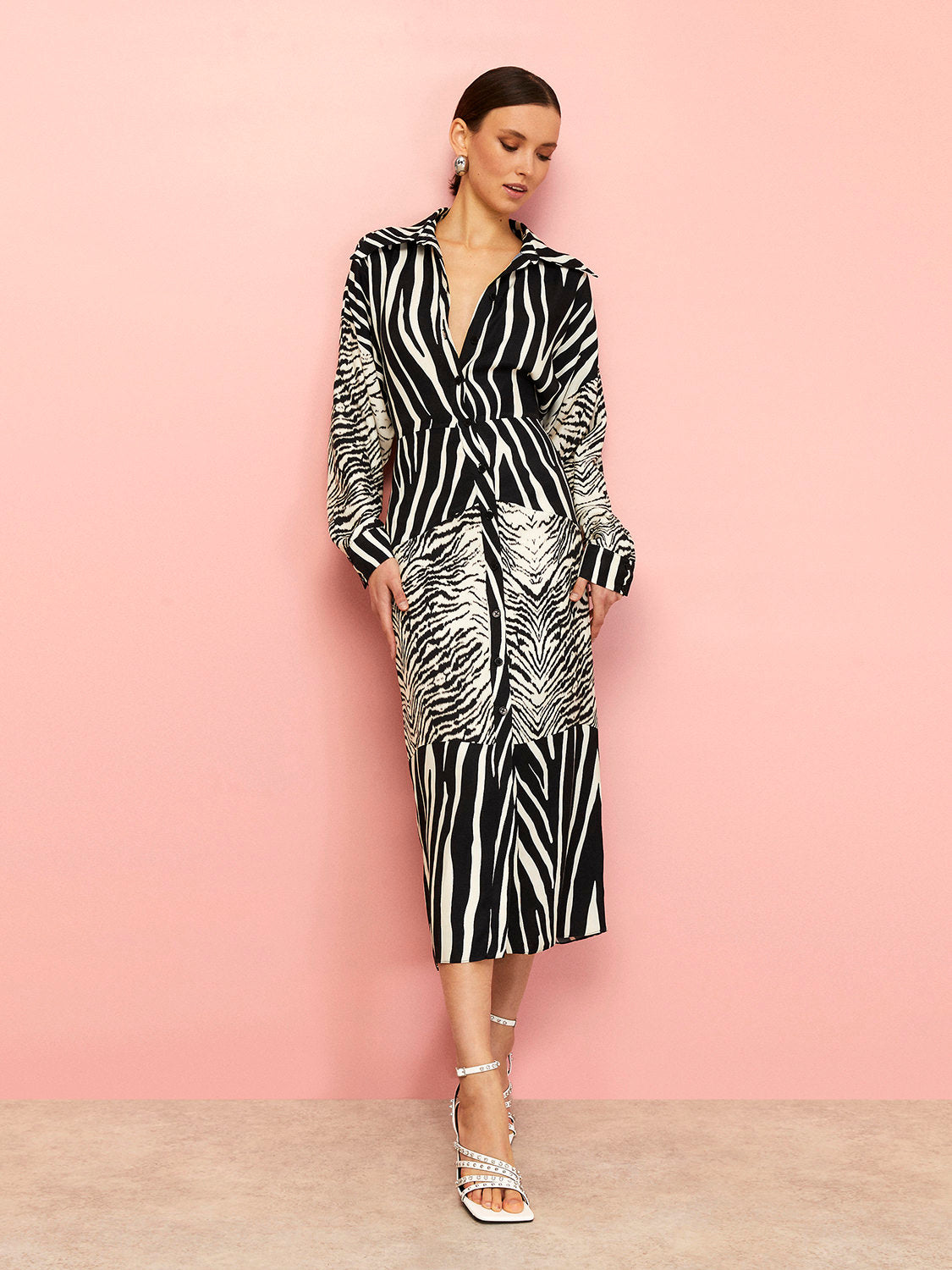 A stylish zebra print shirt dress featuring long batwing sleeves, front button closure, and slit cuffs, perfect for urban chic fashion.