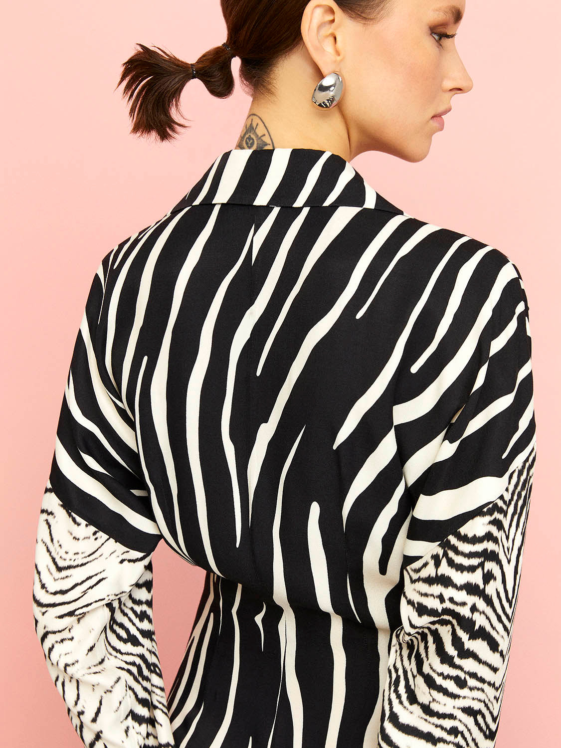 A stylish zebra print shirt dress featuring long batwing sleeves, front button closure, and slit cuffs, perfect for urban chic fashion.