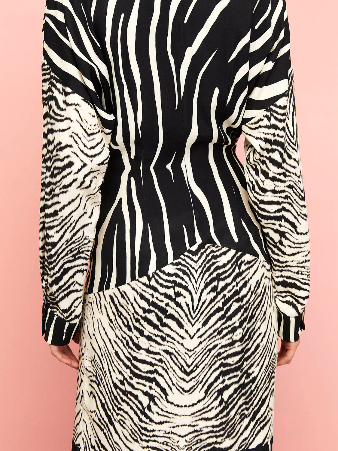 A stylish zebra print shirt dress featuring long batwing sleeves, front button closure, and slit cuffs, perfect for urban chic fashion.