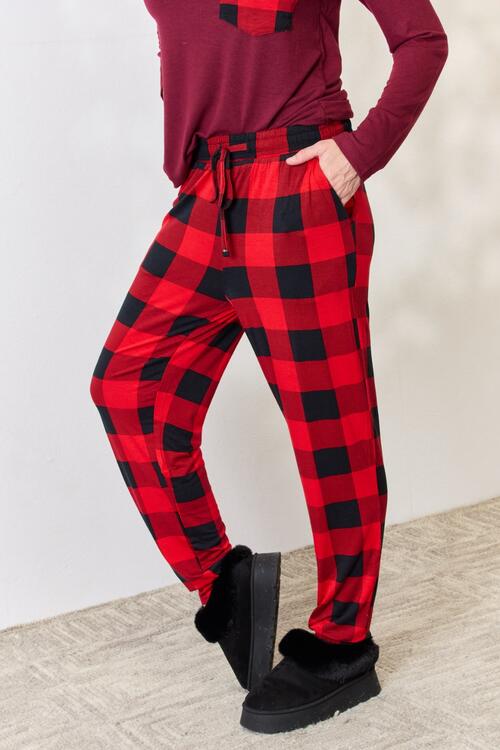 Zenana Full Size Plaid Round Neck Top and Pants Pajama Set featuring a stylish plaid design, front pocket, and drawstring elastic waist pants.